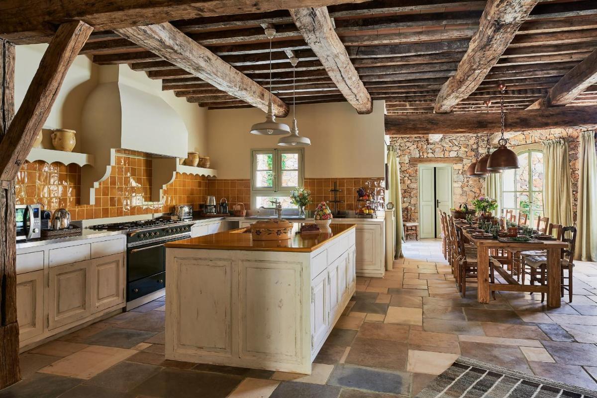 une grande cuisine avec des plafonds en bois et des comptoirs en bois dans l'établissement Château de Berne, à Lorgues