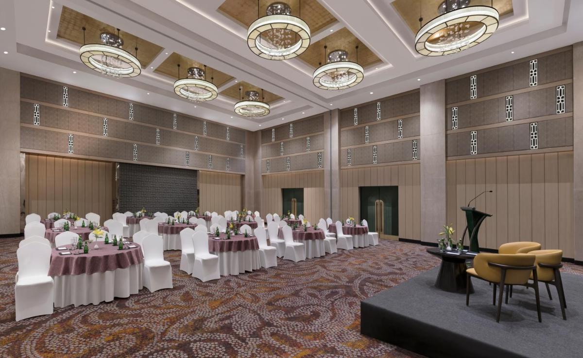 a banquet hall with tables and chairs and a podium at Grand Mercure Agra - An Accor Brand in Agra