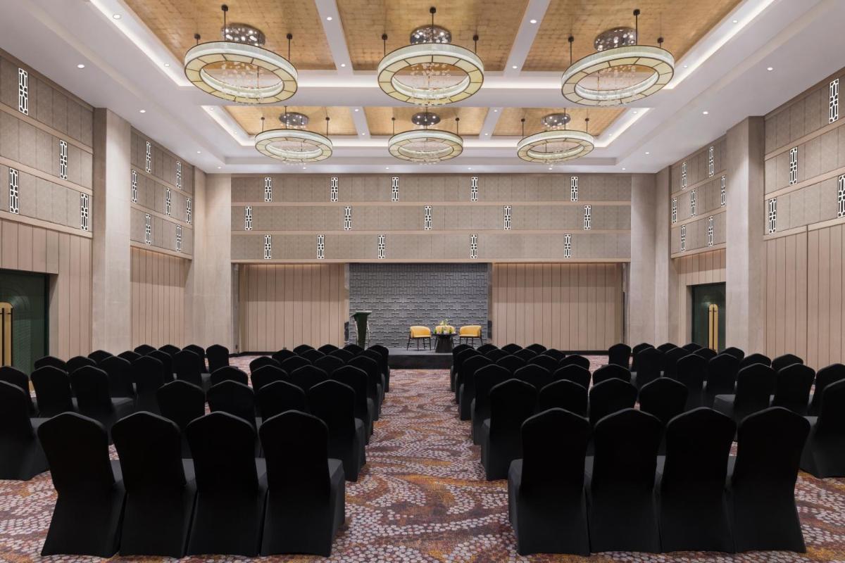 a conference room with black chairs and a screen at Grand Mercure Agra - An Accor Brand in Agra