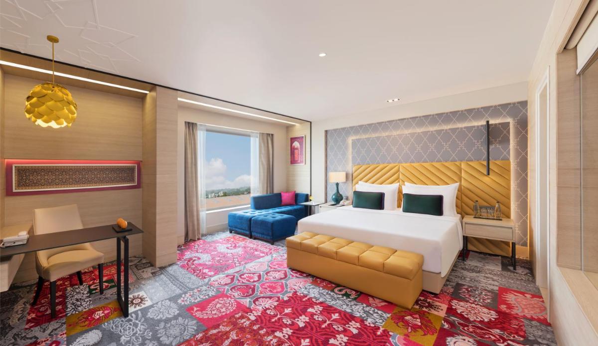 a hotel room with a bed and a desk at Grand Mercure Agra - An Accor Brand in Agra