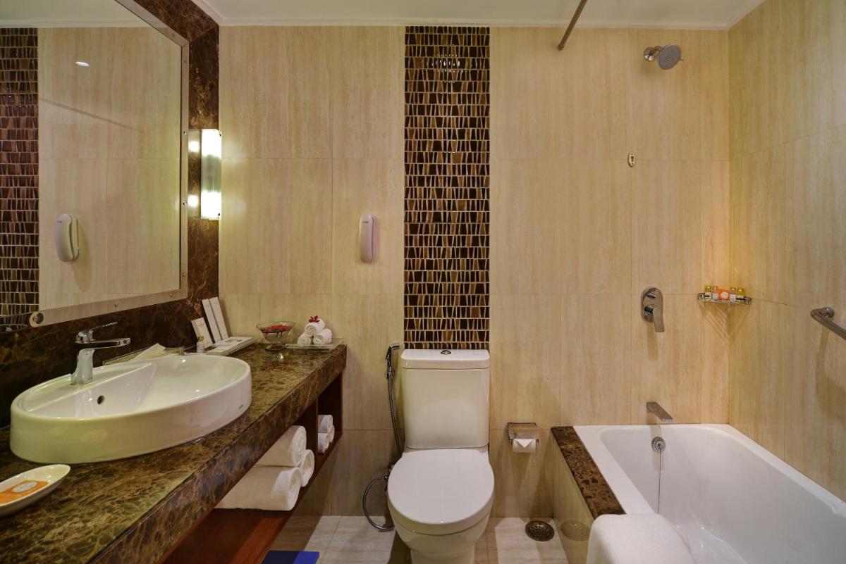 a bathroom with a sink and a toilet and a tub at Radisson Jaipur City Center in Jaipur