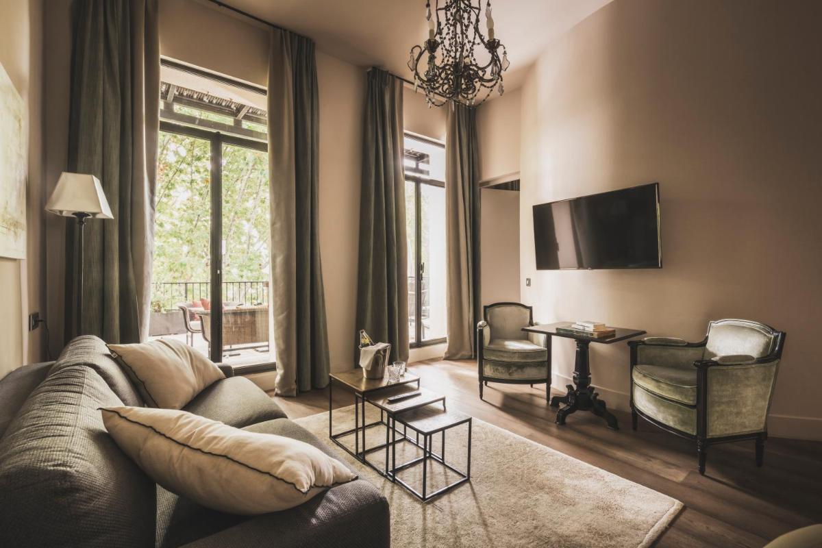 un salon avec un canapé et un bureau dans l'établissement Les Lodges Sainte-Victoire Hotel & Spa, à Aix-en-Provence