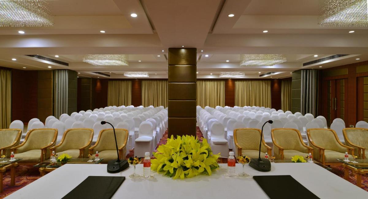 a conference room with white chairs and white tables andatoes at Radisson Jaipur City Center in Jaipur