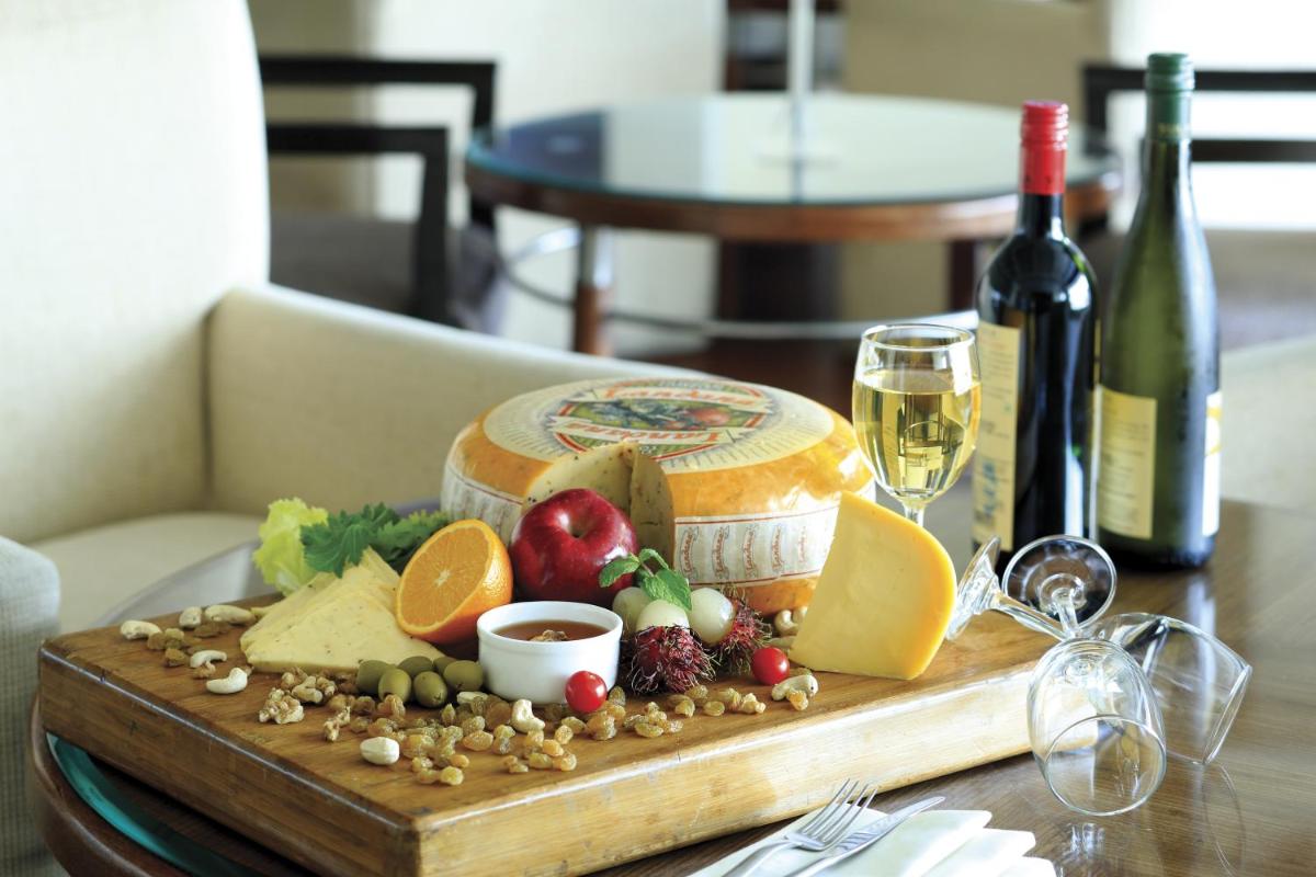 a wooden tray with food and wine on a table at Radisson Jaipur City Center in Jaipur