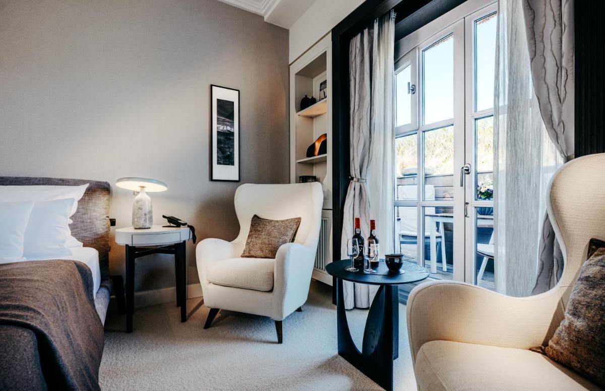 ein Schlafzimmer mit einem Bett und einem Stuhl und einem Fenster in der Unterkunft Söl'ring Hof in Rantum