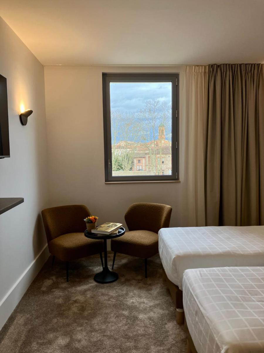 une chambre d'hôtel avec deux lits et une fenêtre dans l'établissement Dali Hôtel Montauban, à Montauban