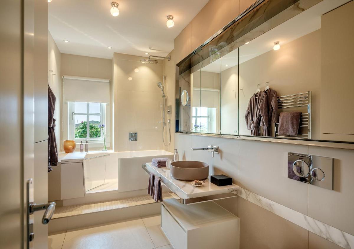 ein Badezimmer mit Waschbecken, Badewanne und Toilette in der Unterkunft Söl'ring Hof in Rantum + 37 Fotos