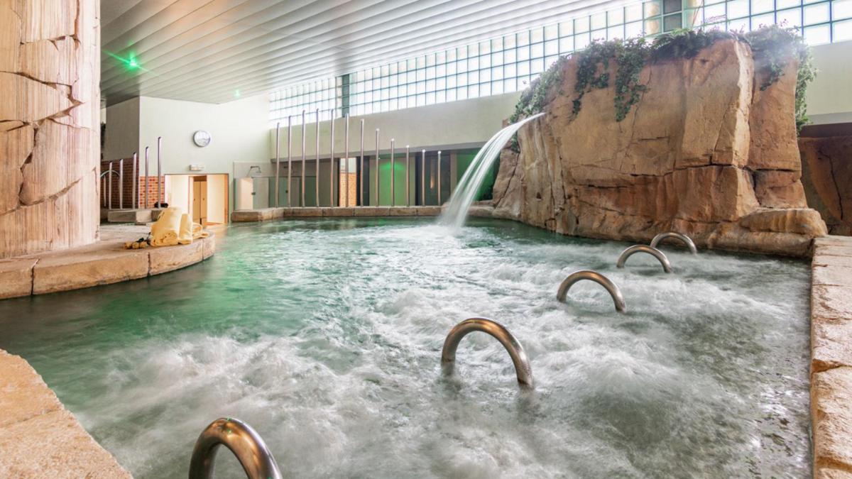 una piscina con cascada en un edificio en Gran Hotel Liber & Spa Playa Golf, en Noja