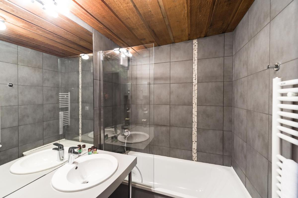 une salle de bains avec lavabo et baignoire dans l'établissement Marmotel & Spa, à Pra-Loup 63 autres photos