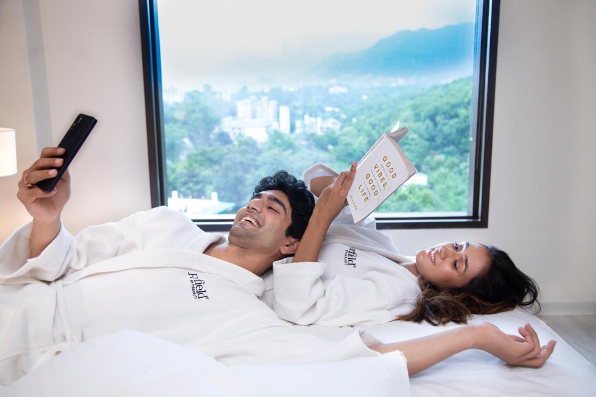 a man and a woman laying in bed reading books at Fairfield by Marriott Dehradun in Dehradun
