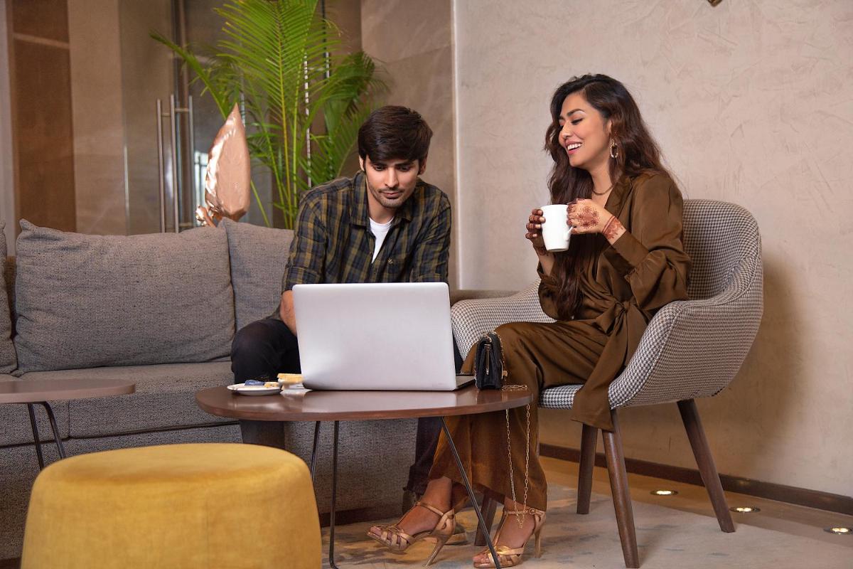 a man and woman sitting around a table with a cup of coffee at Fairfield by Marriott Dehradun in Dehradun