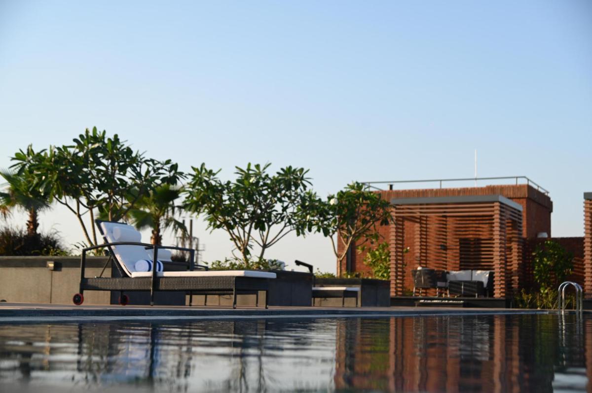 a swimming pool with a chair next to a building at Doubletree By Hilton Bengaluru Whitefield in Bengaluru