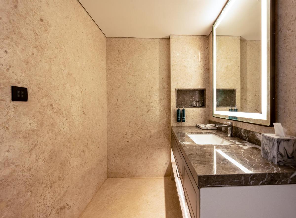 a bathroom with a sink and a mirror at Doubletree By Hilton Bengaluru Whitefield in Bengaluru a bathroom with a sink and a mirror at Doubletree By Hilton Bengaluru Whitefield in Bengaluru