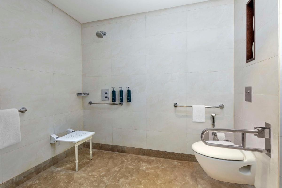 a bathroom with a toilet and a sink at DoubleTree by Hilton Gurugram Baani Square in Gurgaon