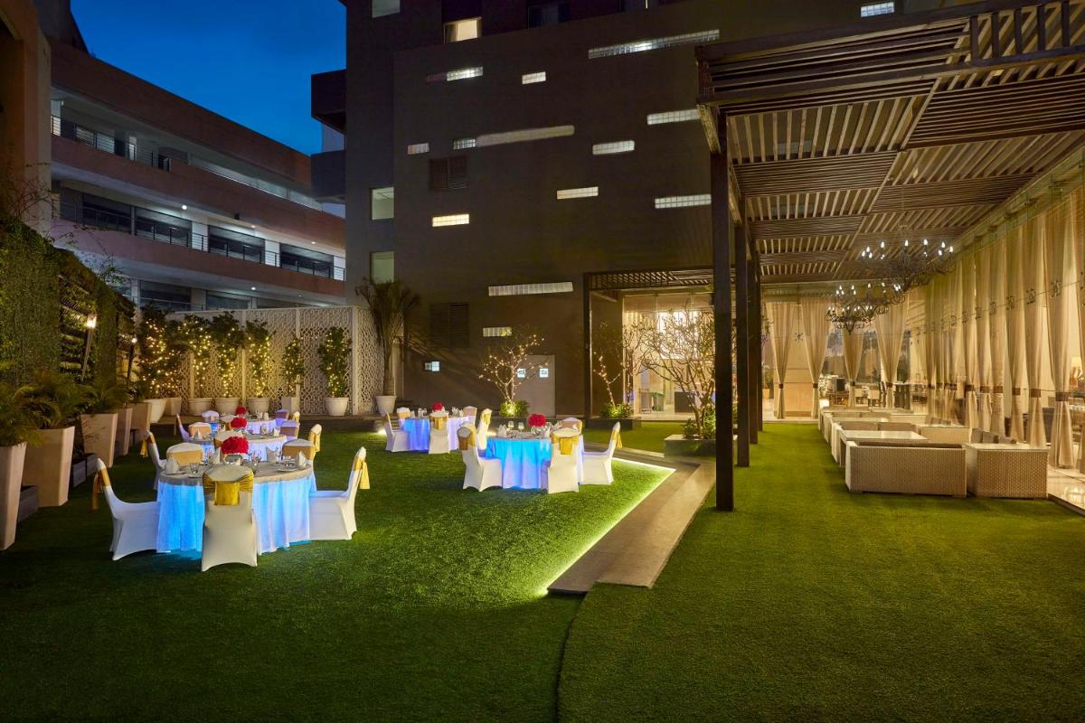 a courtyard with tables and chairs in a building at DoubleTree by Hilton Gurugram Baani Square in Gurgaon