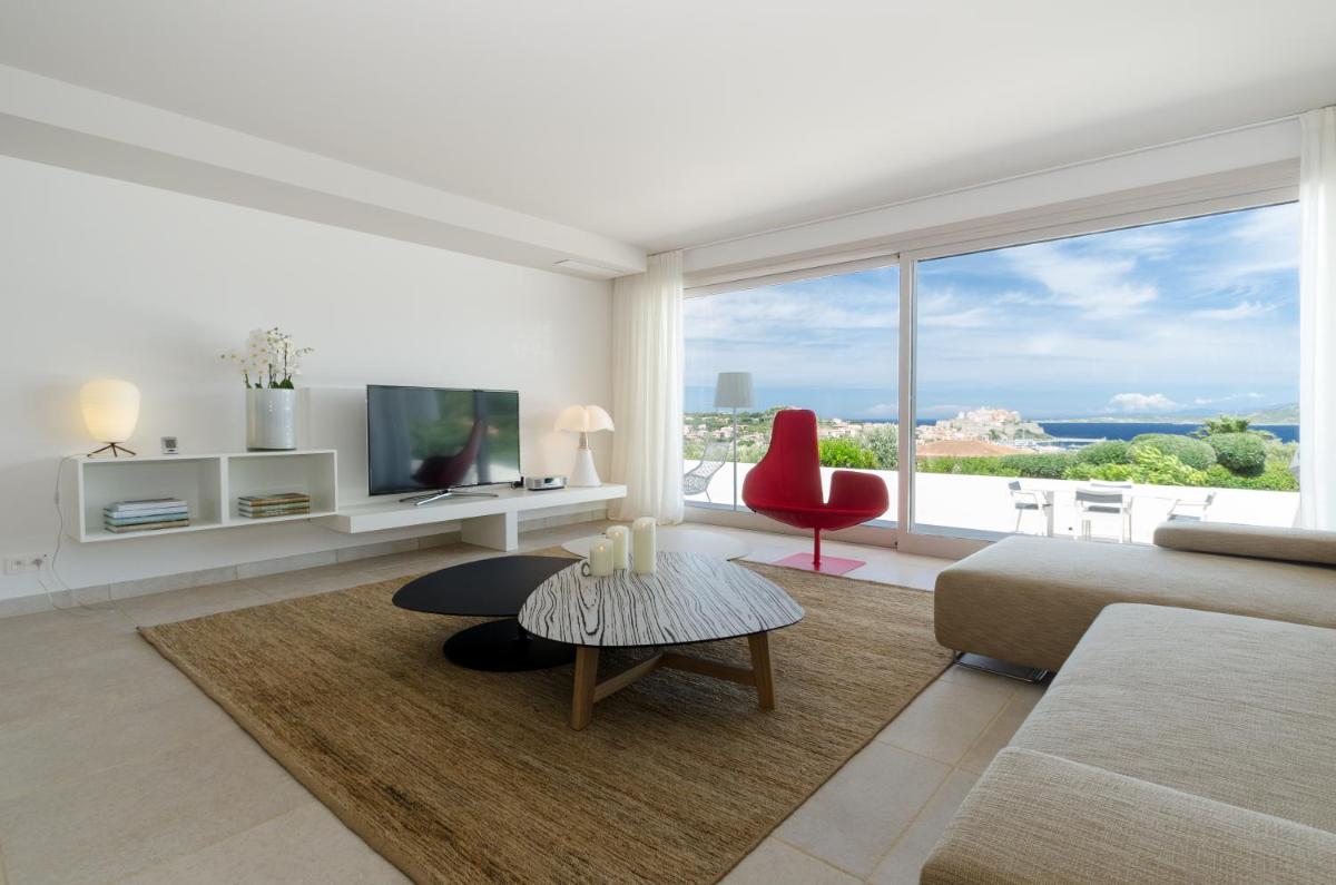 un salon avec un canapé et une chaise rouge dans l'établissement La Villa Calvi, à Calvi