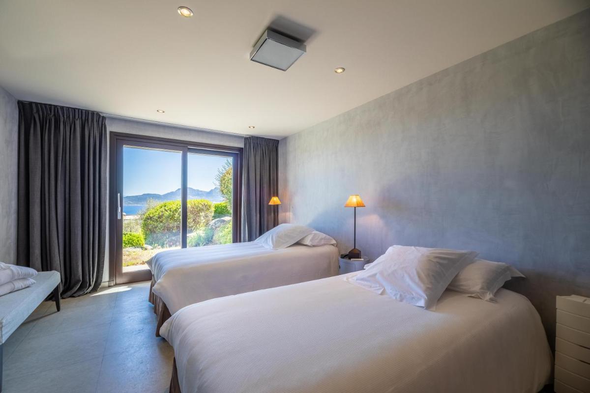 - 2 lits dans une chambre d'hôtel avec une grande fenêtre dans l'établissement La Villa Calvi, à Calvi - 2 lits dans une chambre d'hôtel avec une grande fenêtre dans l'établissement La Villa Calvi, à Calvi
