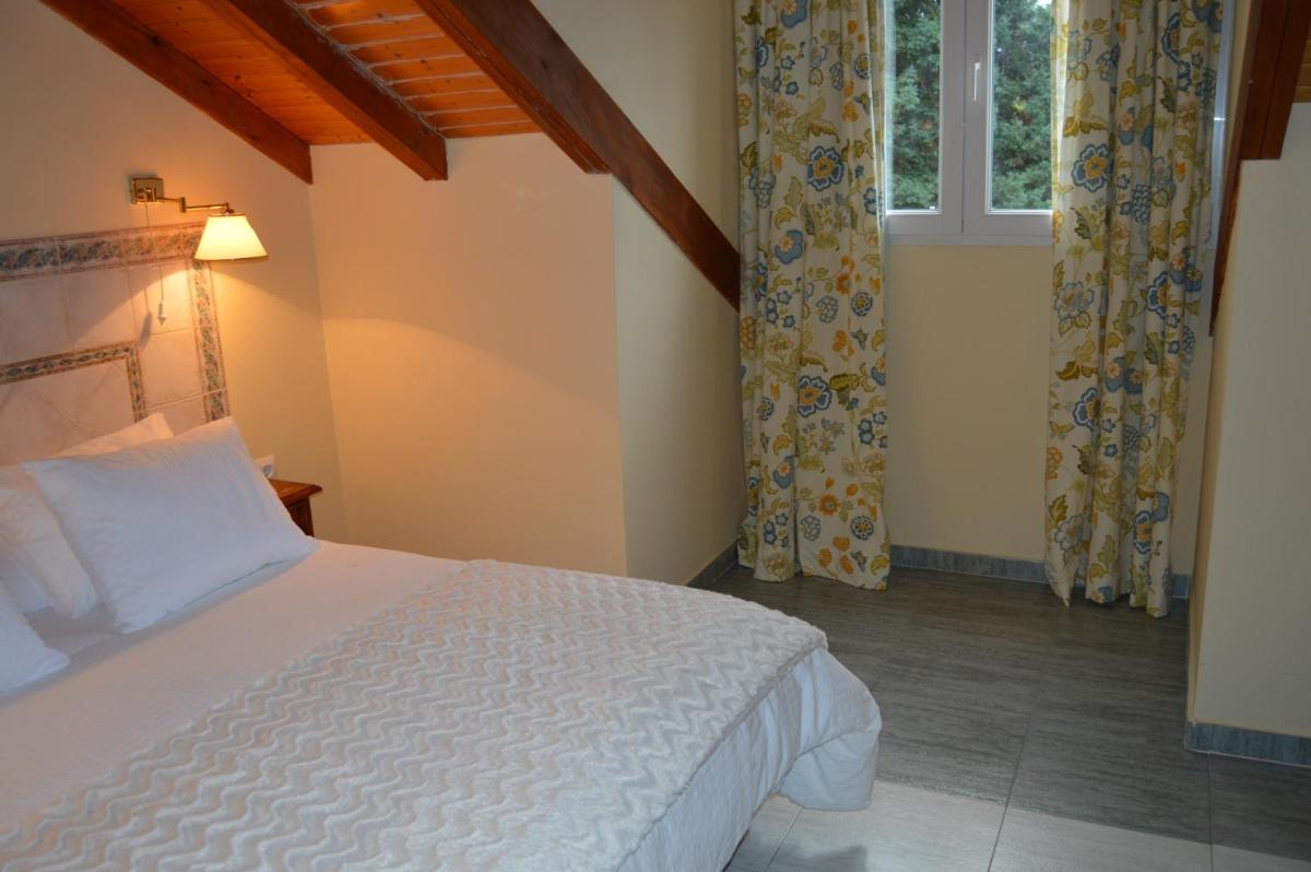 Un dormitorio con una cama blanca y una ventana. en Hotel Balneario De Alceda, en Alceda