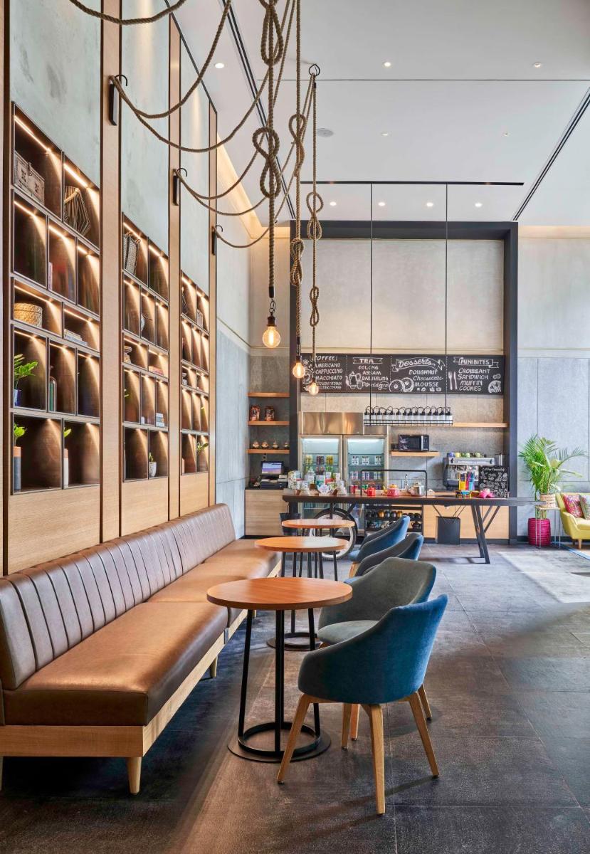 a restaurant with a couch and tables and chairs at Hyatt Centric MG Road Bangalore in Bengaluru a restaurant with a couch and tables and chairs at Hyatt Centric MG Road Bangalore in Bengaluru