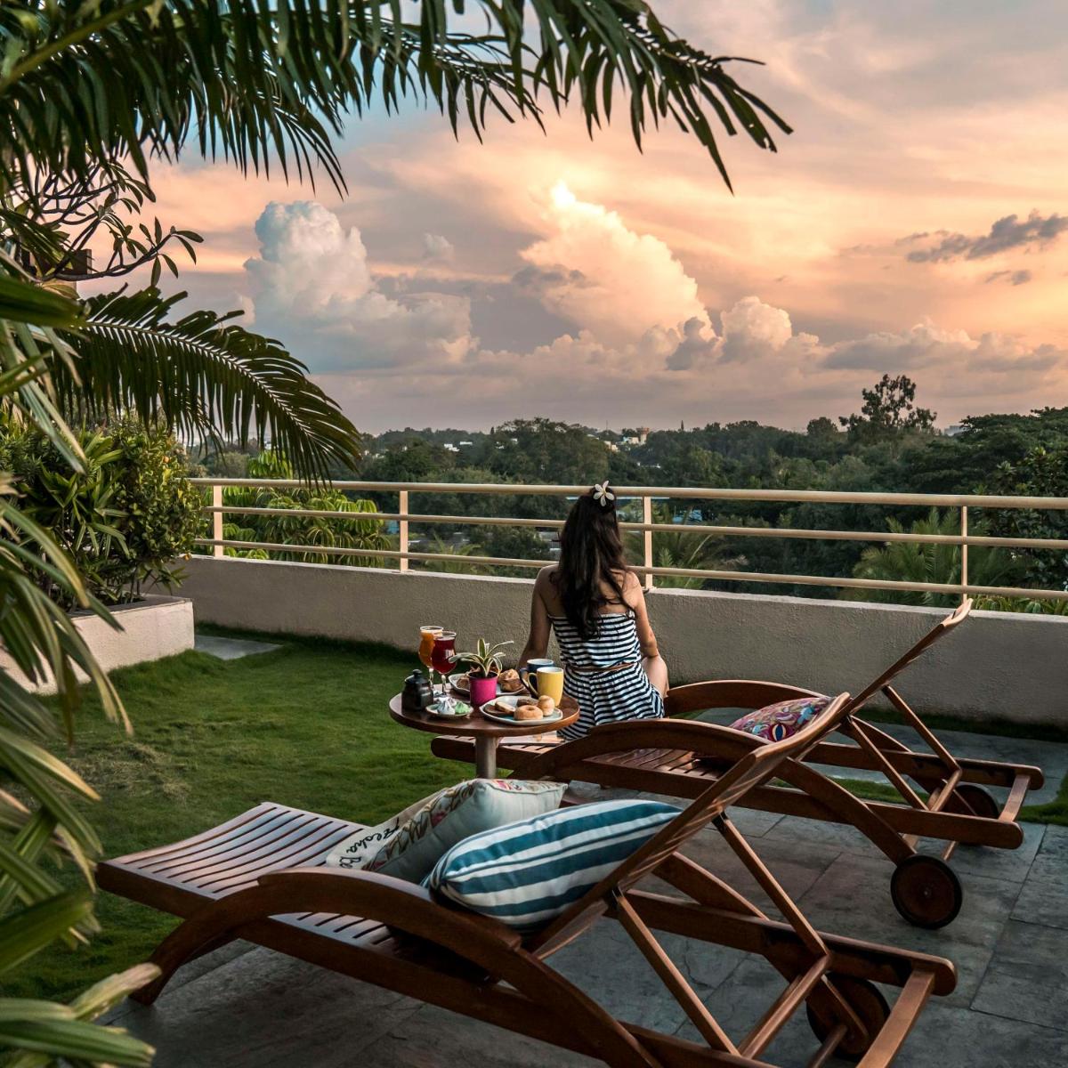 a woman sitting at a table on a balcony at Hyatt Centric MG Road Bangalore in Bengaluru a woman sitting at a table on a balcony at Hyatt Centric MG Road Bangalore in Bengaluru