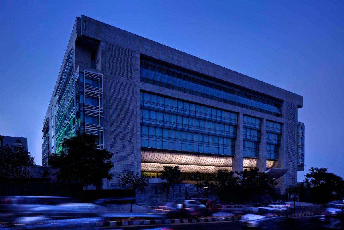 a tall building with cars parked in front of it at Park Hyatt Hotel and Residences, Hyderabad in Hyderabad