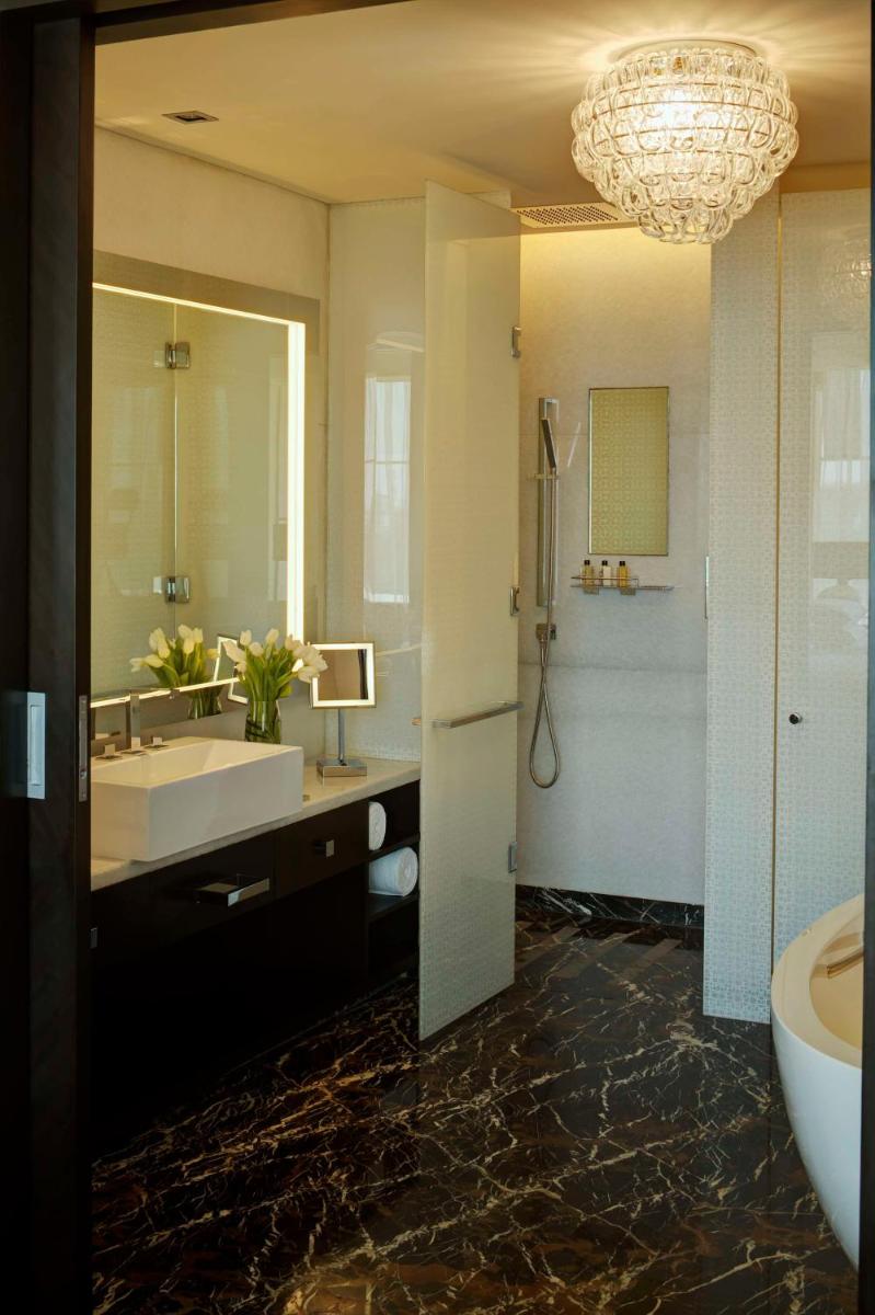 a bathroom with a sink and a tub and a mirror at Park Hyatt Hotel and Residences, Hyderabad in Hyderabad