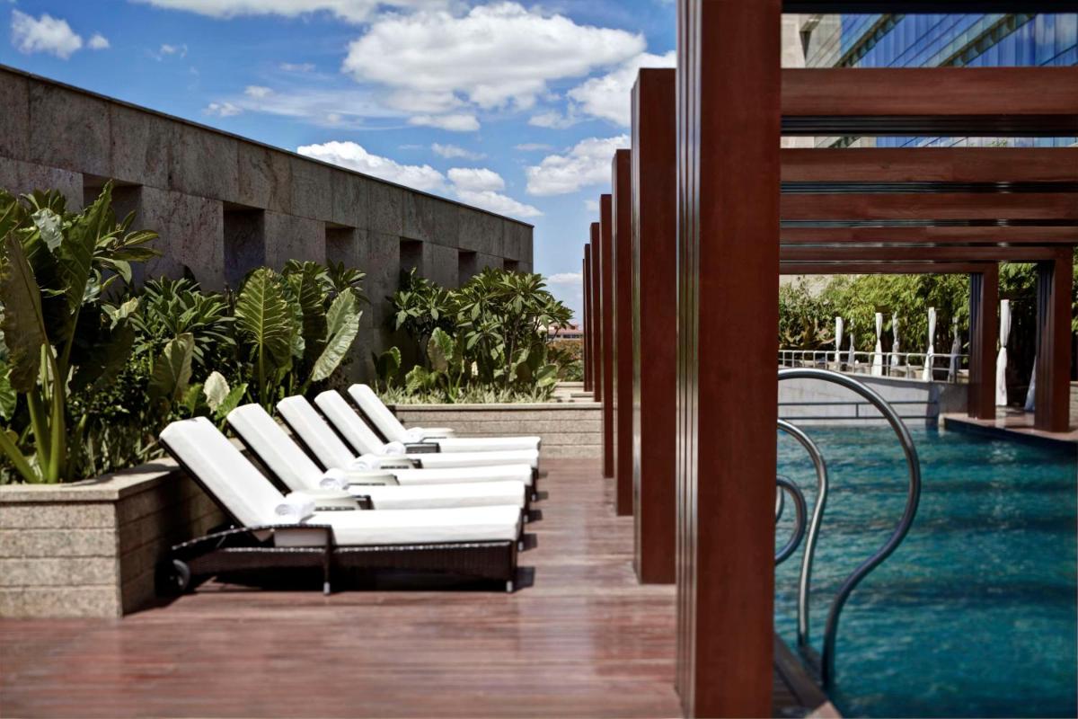 a row of white lounge chairs on a patio at Park Hyatt Hotel and Residences, Hyderabad in Hyderabad