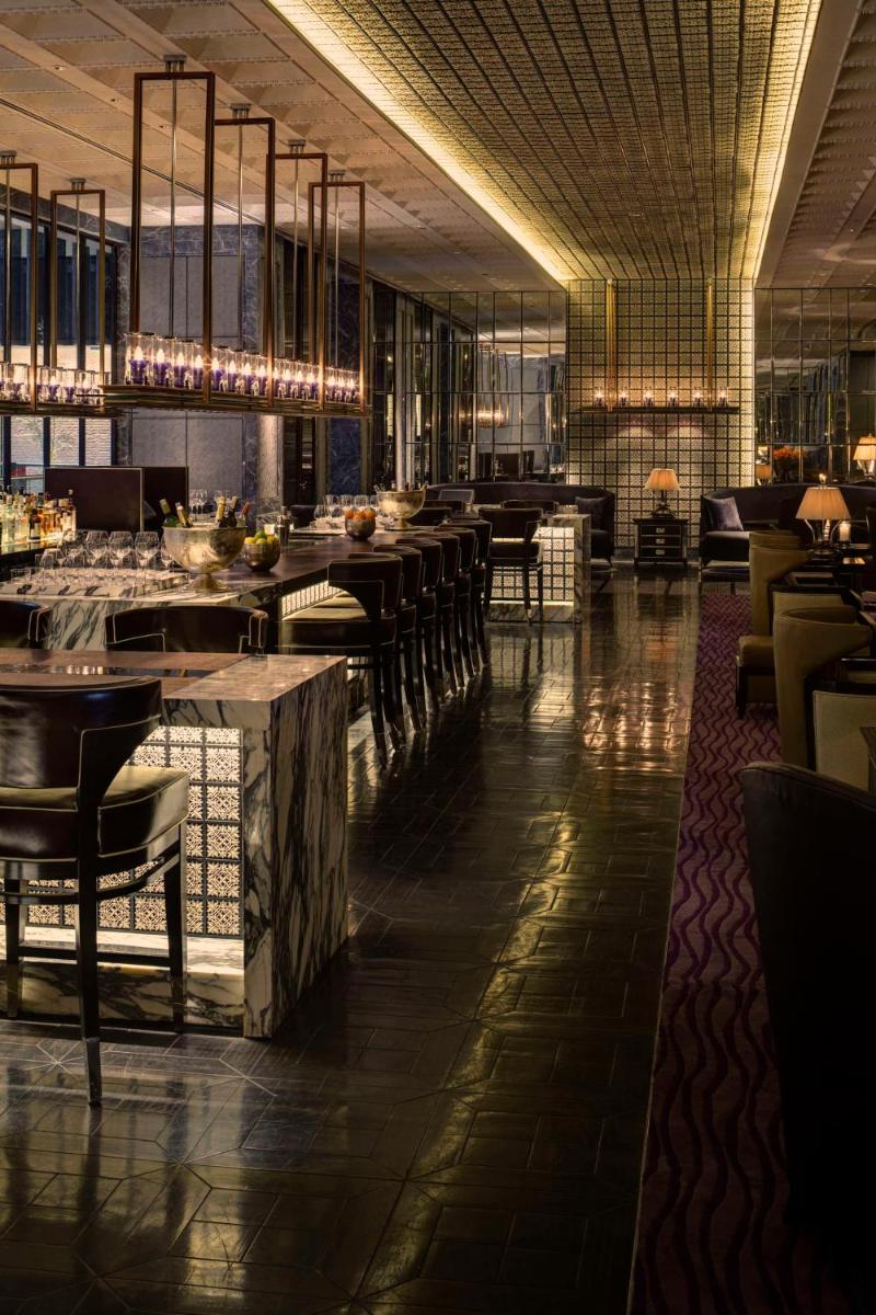 a restaurant with a bar with tables and chairs at Park Hyatt Hotel and Residences, Hyderabad in Hyderabad