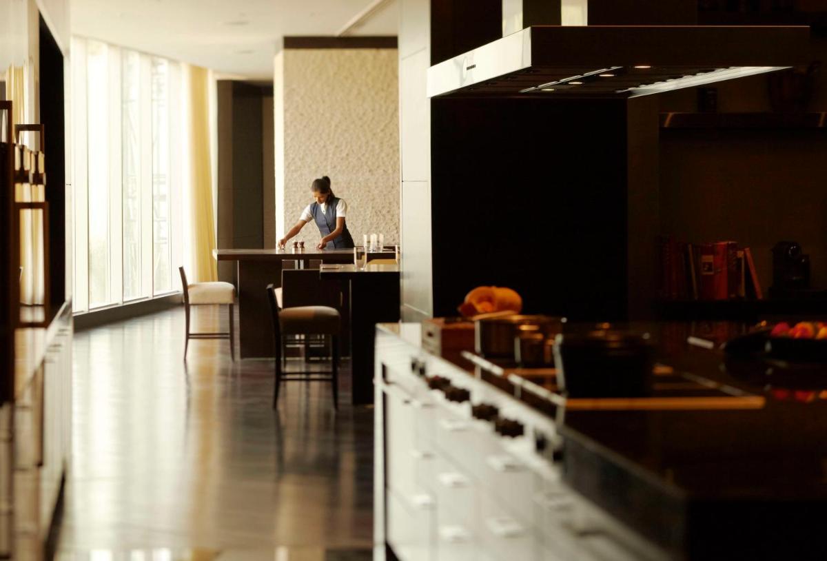 a woman sitting at a counter in a room at Park Hyatt Hotel and Residences, Hyderabad in Hyderabad