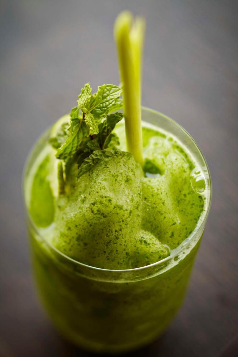 a green smoothie with a yellow straw and a green plant at Park Hyatt Hotel and Residences, Hyderabad in Hyderabad