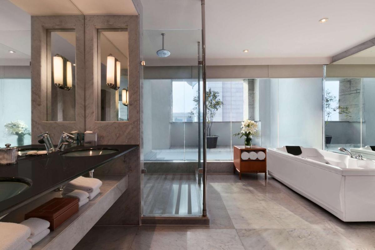 a bathroom with a tub and a sink and a bath tub at Hyatt Regency Kolkata in Kolkata a bathroom with a tub and a sink and a bath tub at Hyatt Regency Kolkata in Kolkata