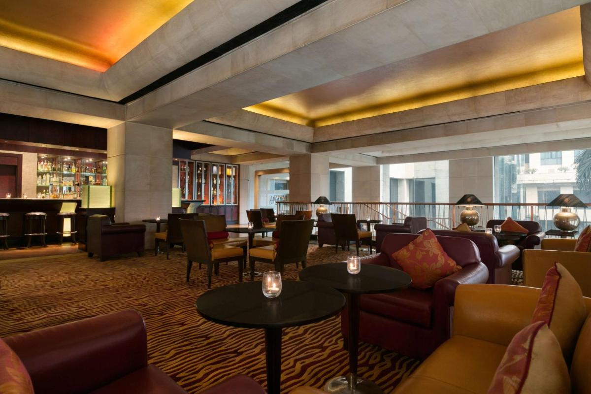 a hotel lobby with couches and tables and a bar at Hyatt Regency Kolkata in Kolkata a hotel lobby with couches and tables and a bar at Hyatt Regency Kolkata in Kolkata