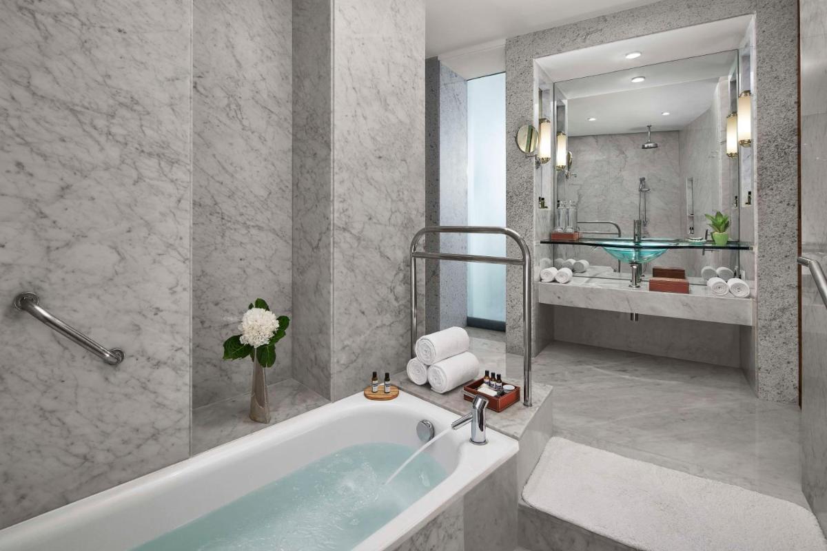 a bathroom with a bath tub and a sink at Hyatt Regency Kolkata in Kolkata a bathroom with a bath tub and a sink at Hyatt Regency Kolkata in Kolkata