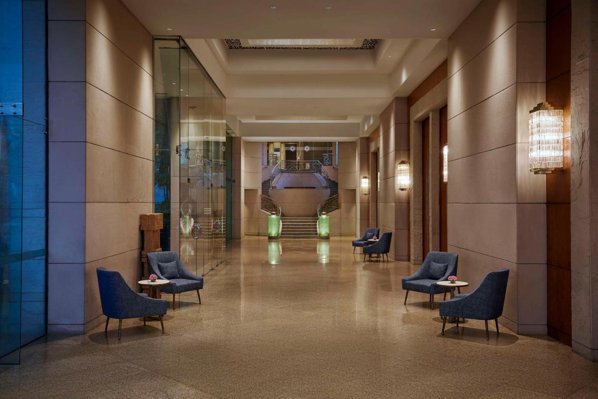a lobby with chairs and a train in the distance at Hyatt Regency Kolkata in Kolkata a lobby with chairs and a train in the distance at Hyatt Regency Kolkata in Kolkata