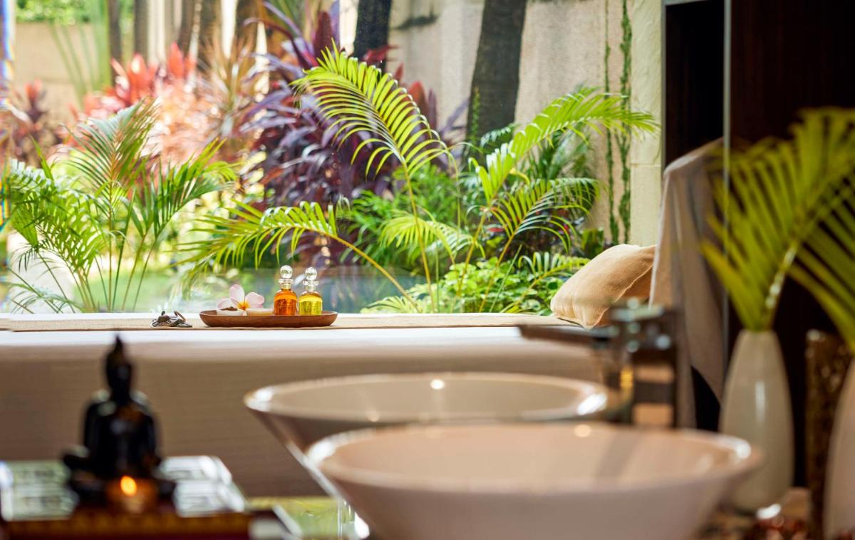 a bathroom with a sink and a window with plants at Hyatt Regency Kolkata in Kolkata a bathroom with a sink and a window with plants at Hyatt Regency Kolkata in Kolkata