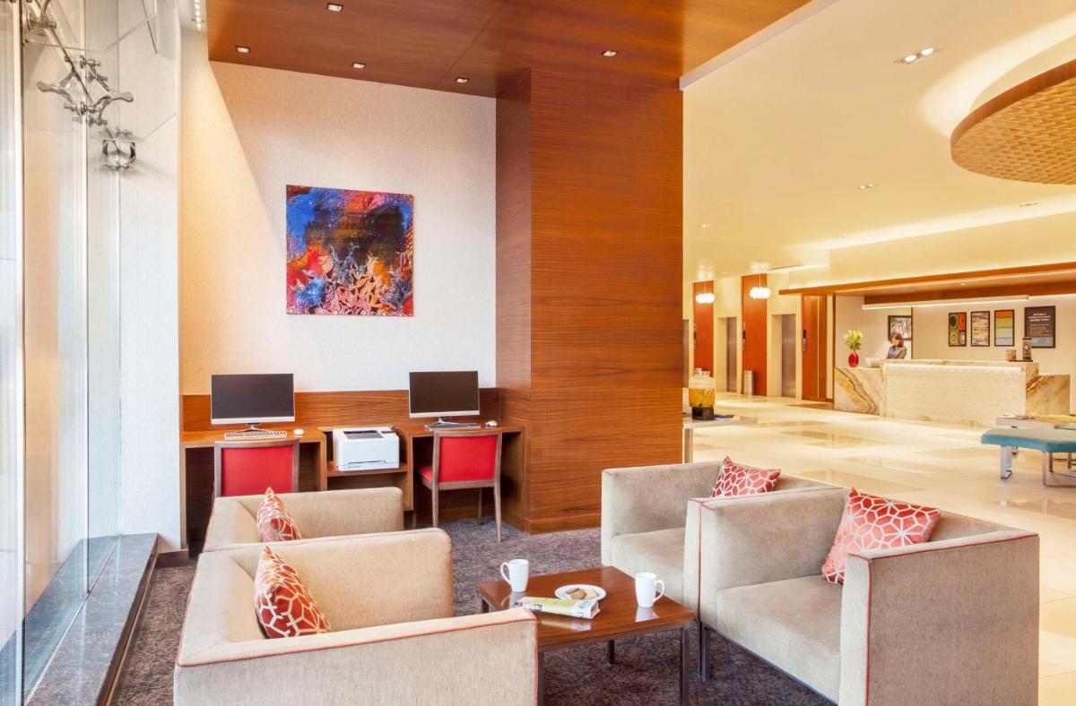 a lobby of a hotel with chairs and a table at Hyatt Place Hyderabad Banjara Hills in Hyderabad
