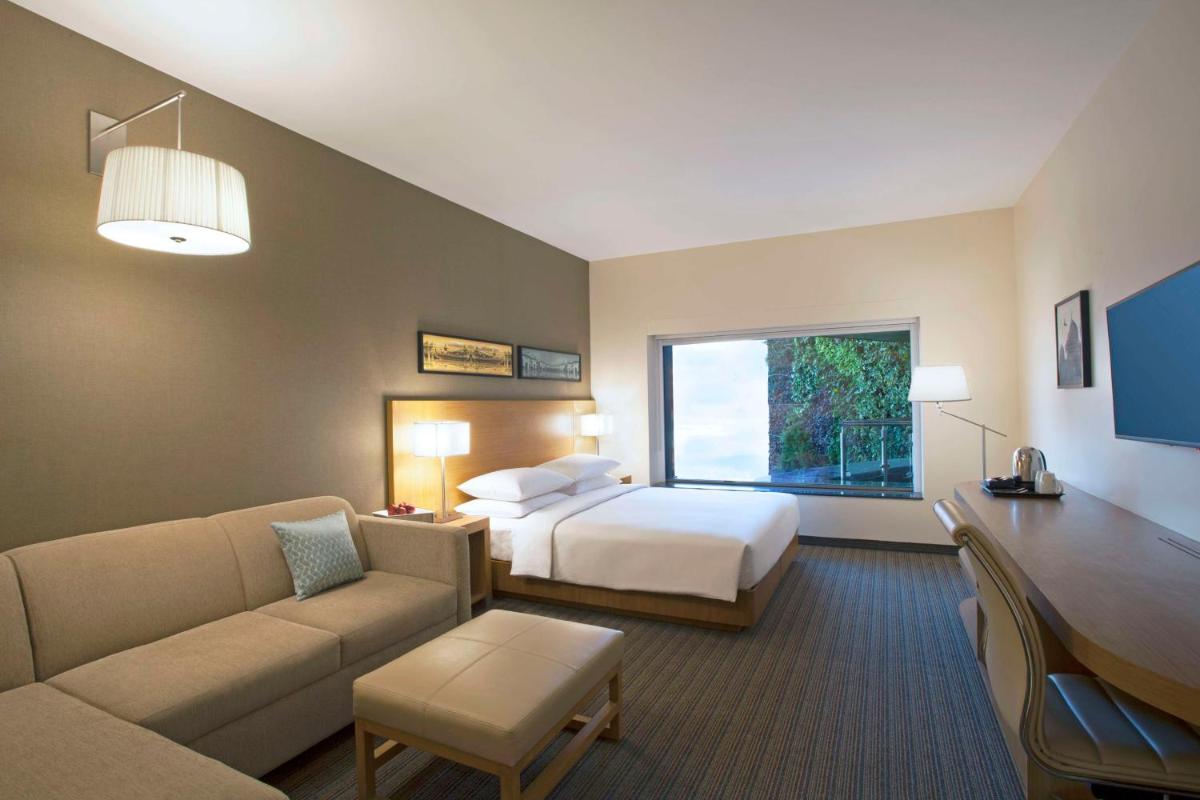 a hotel room with a bed and a couch at Hyatt Place Hyderabad Banjara Hills in Hyderabad