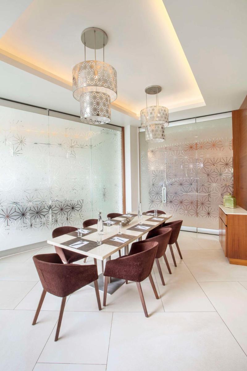a dining room with a long table and chairs at Hyatt Place Hyderabad Banjara Hills in Hyderabad
