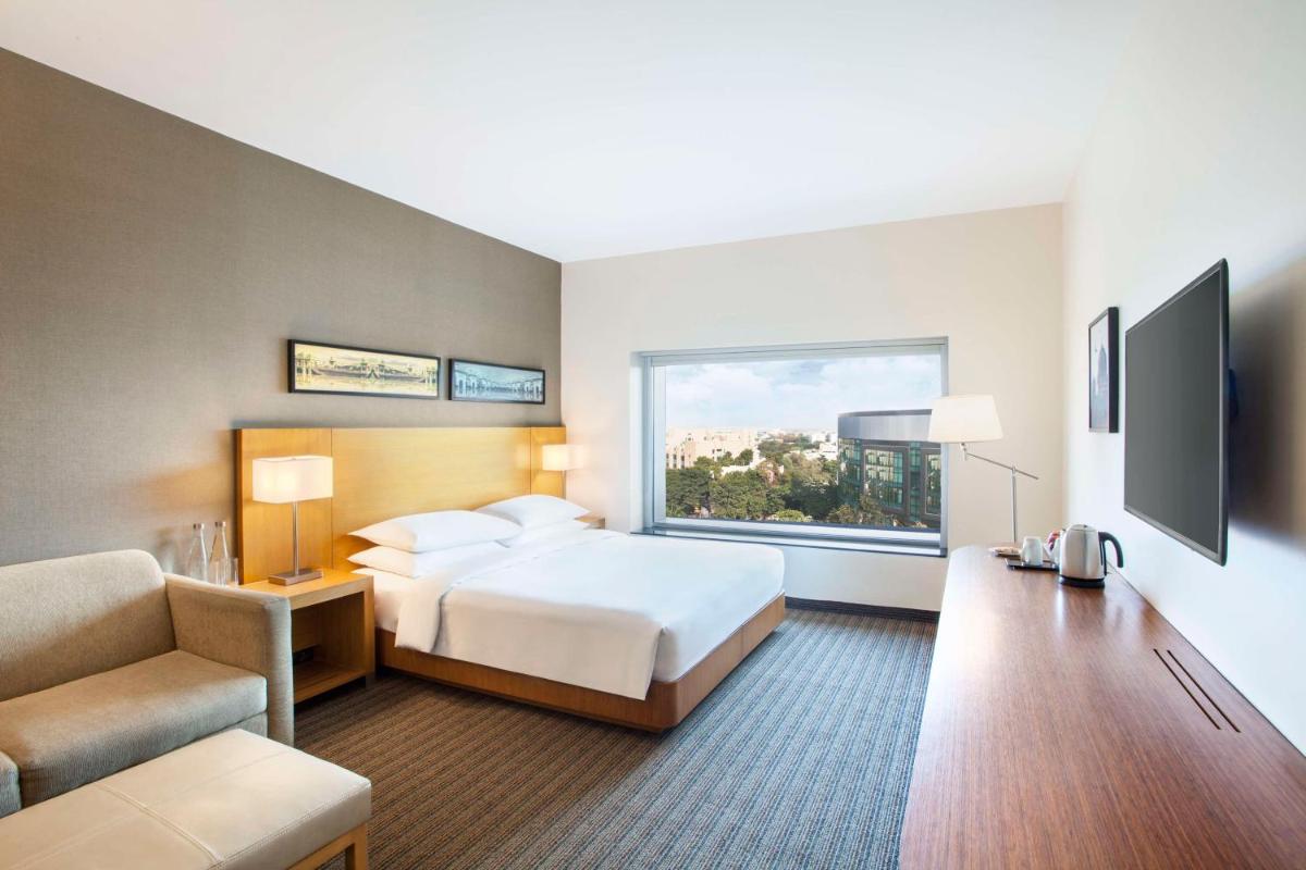 a hotel room with a bed and a window at Hyatt Place Hyderabad Banjara Hills in Hyderabad