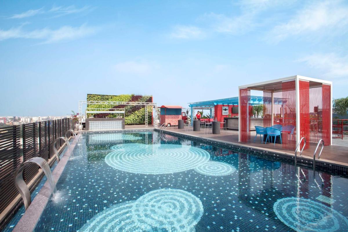 a swimming pool on the roof of a building at Hyatt Place Hyderabad Banjara Hills in Hyderabad