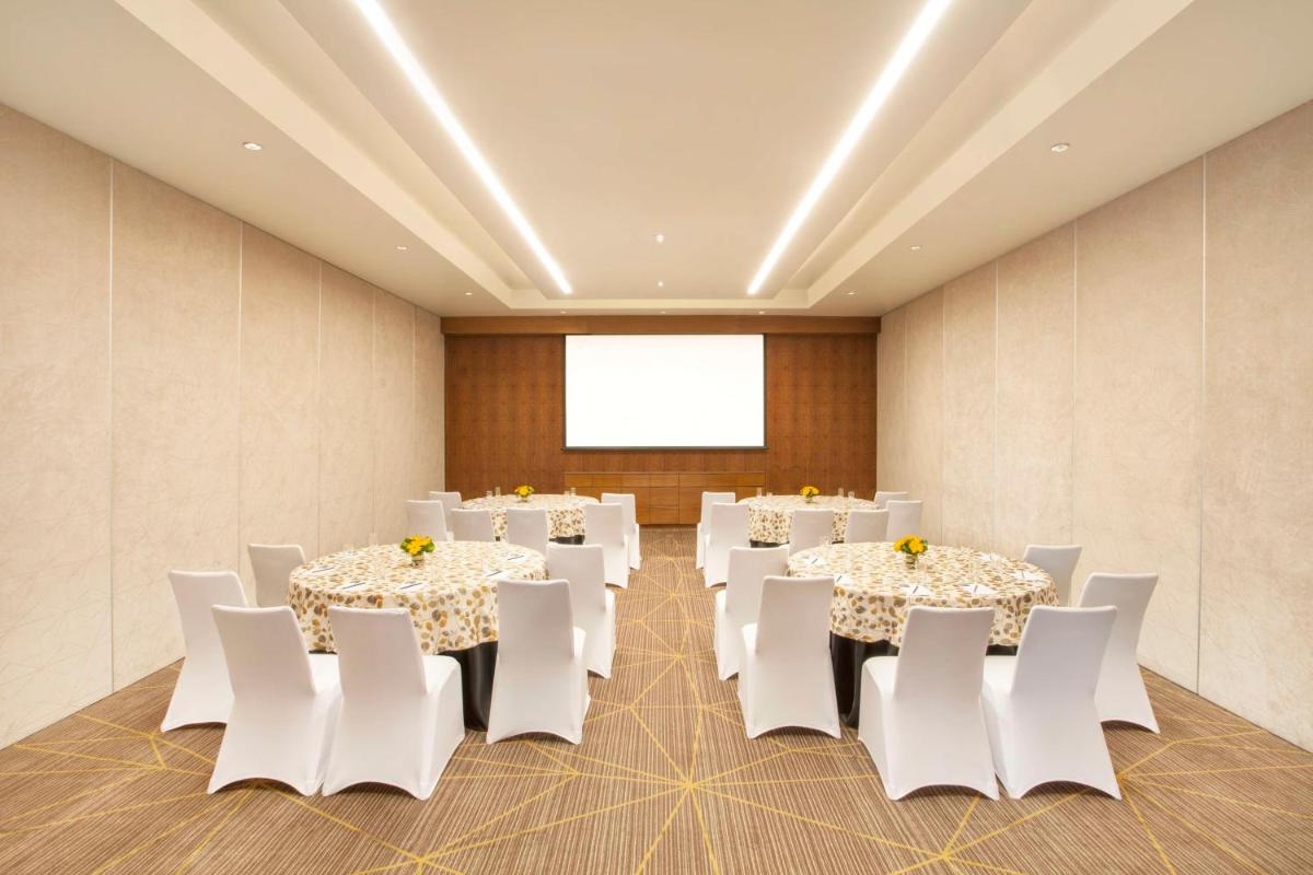 a conference room with white tables and white chairs at Hyatt Place Hyderabad Banjara Hills in Hyderabad