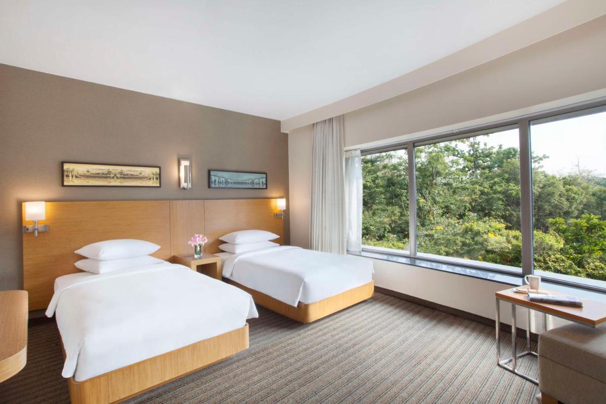 a hotel room with two beds and a window at Hyatt Place Hyderabad Banjara Hills in Hyderabad