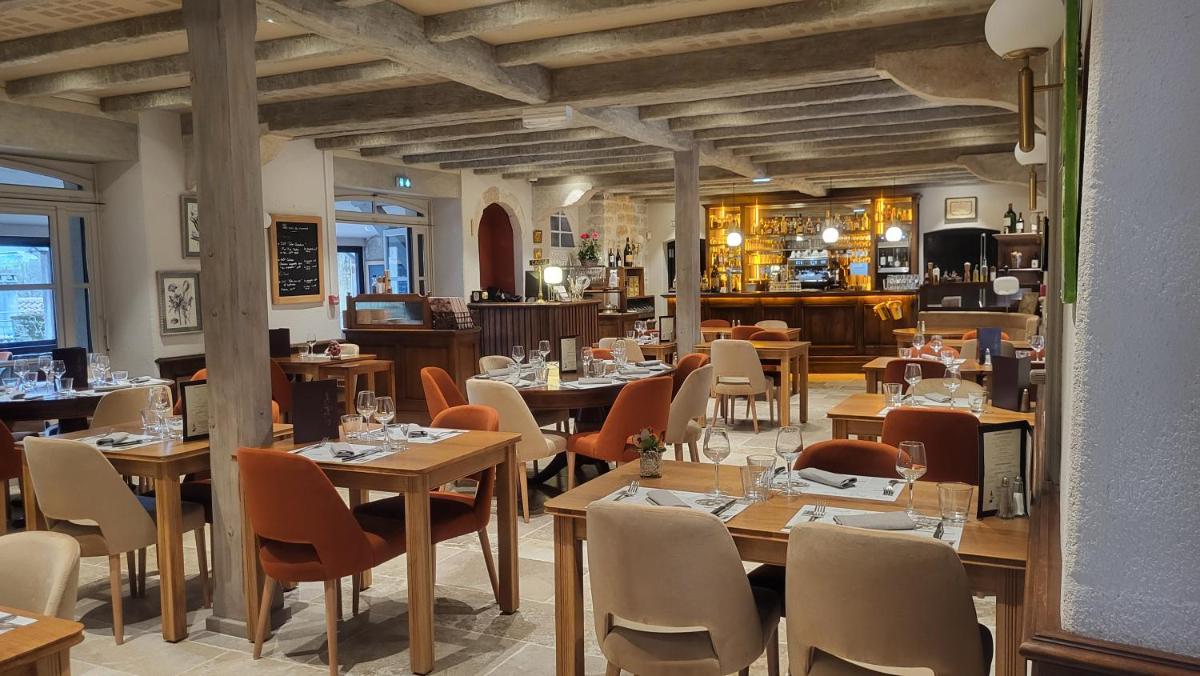 un restaurant avec des tables et des chaises dans une salle dans l'établissement Hôtel Spa La Truite Dorée, à Vers
