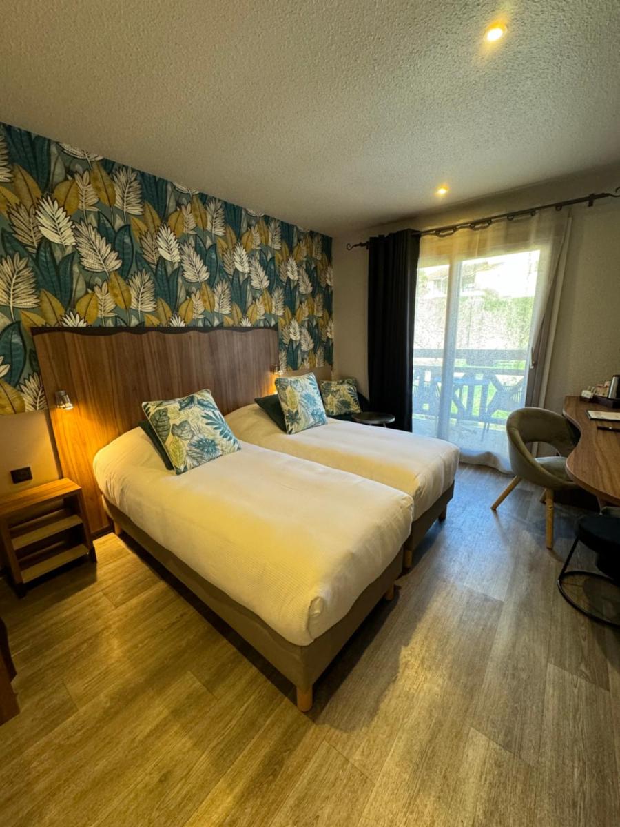 une chambre d'hôtel avec deux lits et une fenêtre dans l'établissement Hôtel Spa La Truite Dorée, à Vers