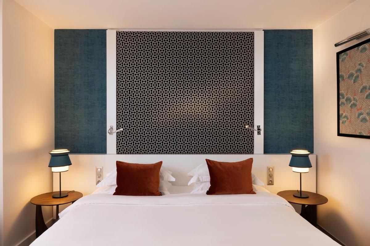 une chambre avec un grand lit blanc avec deux lampes dans l'établissement Hôtel Etoile Maillot, à Paris