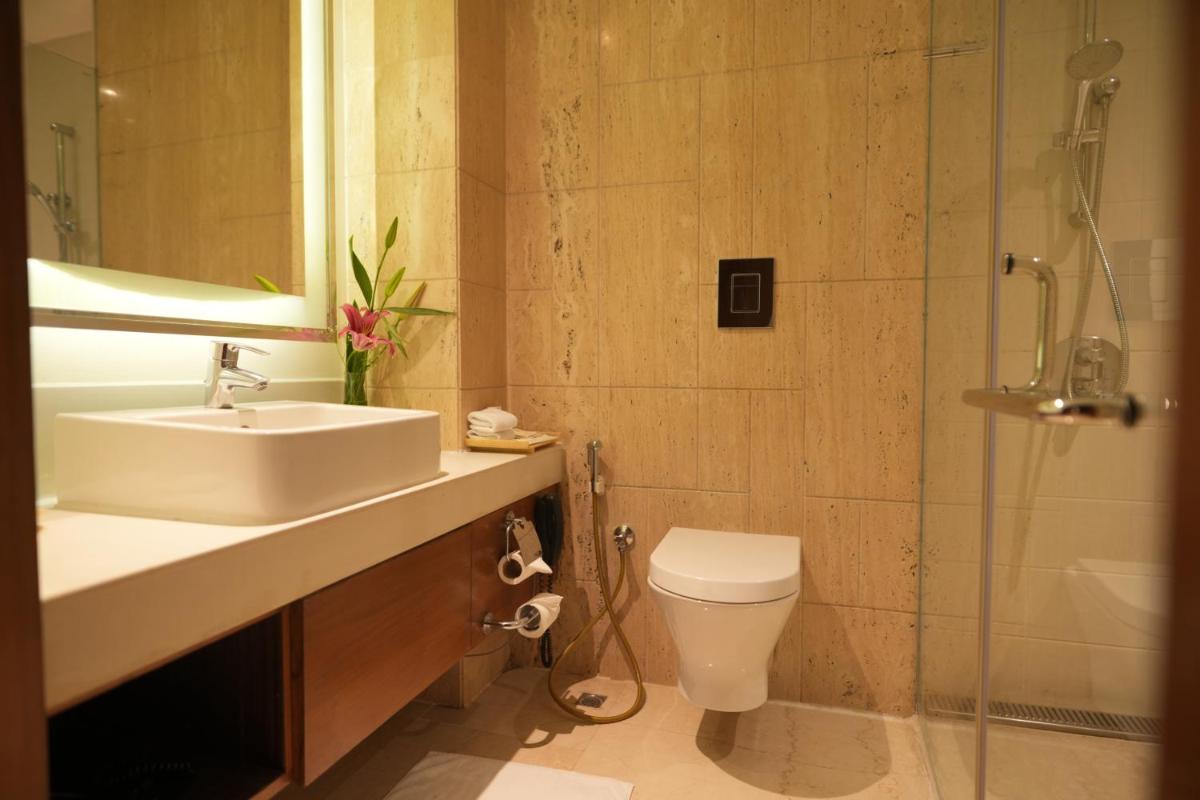 a bathroom with a sink and a toilet and a shower at DoubleTree by Hilton Gurgaon New Delhi NCR in Gurgaon