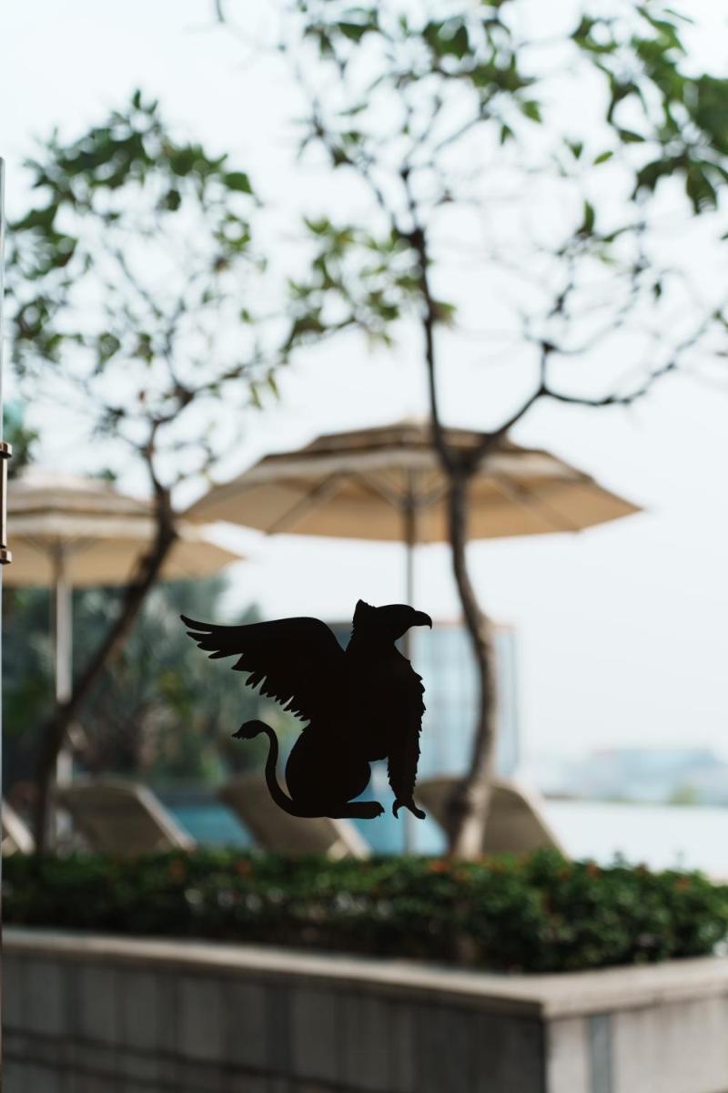 a black bird flying in front of an umbrella at JW Marriott Hotel Kolkata in Kolkata