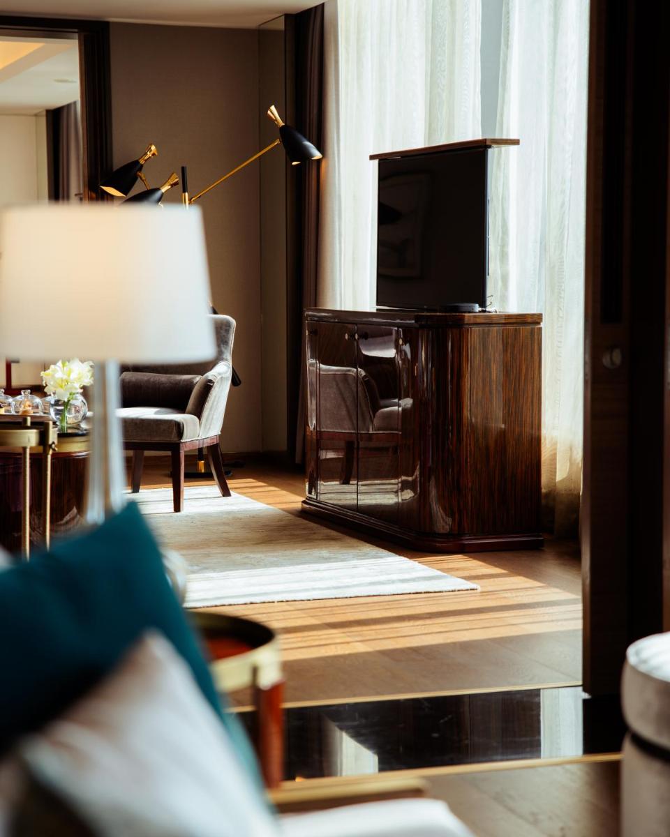 a living room with a television and a couch and a chair at JW Marriott Hotel Kolkata in Kolkata
