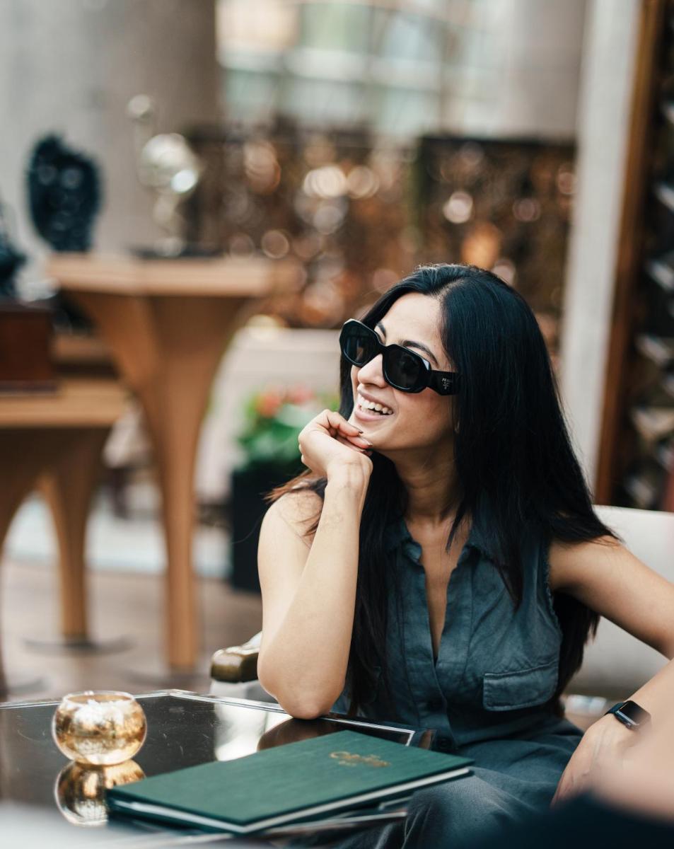 a woman sitting at a table talking on a cell phone at JW Marriott Hotel Kolkata in Kolkata