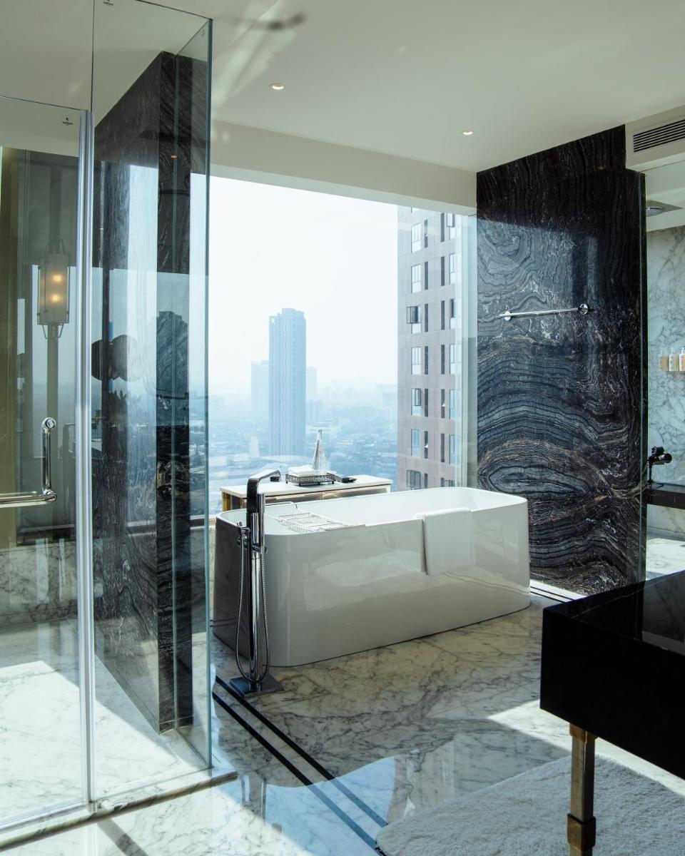 a bathroom with a white tub and a glass wall at JW Marriott Hotel Kolkata in Kolkata